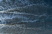 waves are rolling in a shallow pool near a beach at high tide and the sandy shore