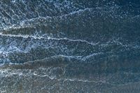 waves are rolling in a shallow pool near a beach at high tide and the sandy shore