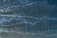 waves are rolling in a shallow pool near a beach at high tide and the sandy shore