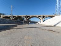 there are three arches over a bridge and no traffic on it to provide shade or light