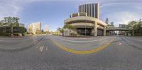 this is an image of a empty street in the city at daytime, with buildings and cars going up to their sides