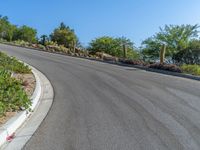 a very long winding road that goes up a mountain top into the desert area with some plants