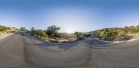 the camera shows the side view of the road with mountains and shrubs on either side