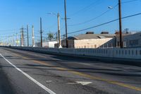 empty highway with stop sign and buildings in the distance on a sunny day next to an alley