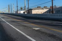 empty highway with stop sign and buildings in the distance on a sunny day next to an alley