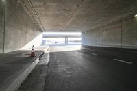 empty road with light and traffic going into tunnel in winter day, near highway sign