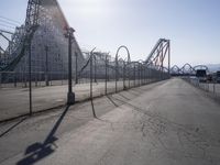 a long road surrounded by a row of roller coasters and an obstacle track next to it