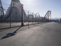 a long road surrounded by a row of roller coasters and an obstacle track next to it