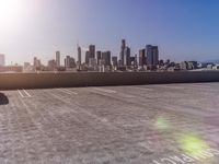 an empty parking lot on the roof with a city in the background and buildings in the distance