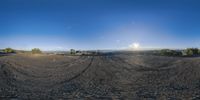 a panoramic view of desert and sky with clouds in the background from a car window