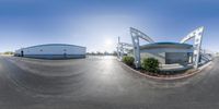 a fish - eye view looking at a shopping center and parking lot from the bottom of a round panorama lens