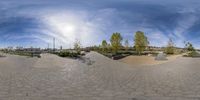 a skate park with a view of the sky through it and people at their feet