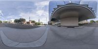 a fish - eye lens view of a skateboard park with stairs and large building in background