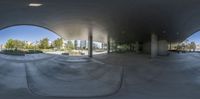 a view from outside looking at a skating park with a circular mirror on the wall