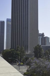 a picture of a building near some trees and buildings and blue skies with clouds on the horizon