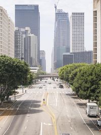 city with tall buildings and street signs on a busy road near some trees and a city street