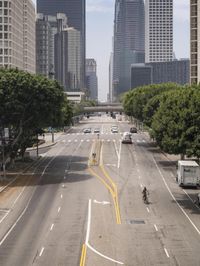 city with tall buildings and street signs on a busy road near some trees and a city street