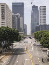 city with tall buildings and street signs on a busy road near some trees and a city street