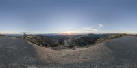 this is an 360 - angle lens view of the top of a hill looking down at a road