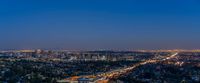 the view from a hill looking over los city at night with a freeway passing by