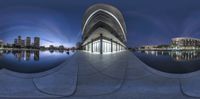 two spherical views of city buildings and a pond at night, in a panoramic picture