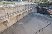 a small bridge over concrete and concrete construction with an iron rod in front of it