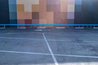 this photo shows some parking lots with paint blockings in it's area, including a giant painted mural