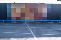 this photo shows some parking lots with paint blockings in it's area, including a giant painted mural