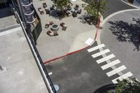 a view of the street looking down from a building with several tables in the middle