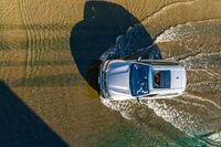 a boat is driving through the shallow water, and its wake is making it's way through