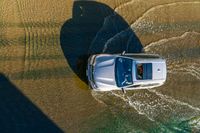 a boat is driving through the shallow water, and its wake is making it's way through