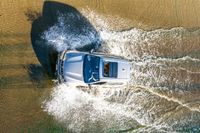 a boat is driving through the shallow water, and its wake is making it's way through