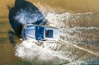 a boat is driving through the shallow water, and its wake is making it's way through