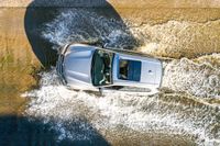 a boat is driving through the shallow water, and its wake is making it's way through