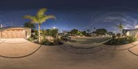 a 360 view of two skateboarders and a parking lot at night with a building on one side and a driveway to the other