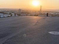 a person jumping a skateboard on a skate ramp in the sun set with power lines in the background