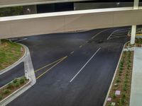 a view of a road and an overpass with traffic passing through it by buildings