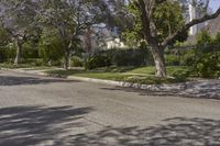 a red fire hydrant is sitting in front of a house with trees near by