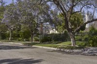 a red fire hydrant is sitting in front of a house with trees near by