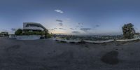 fish - eye view of an exterior of a house and car park at dusk with the sun setting and the sky in background