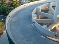 an aerial view of the skateboarder on top of a ramp in front of a residential building