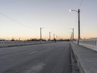 an empty street is shown with lights above it and in the background, power lines