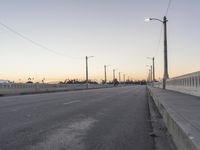 an empty street is shown with lights above it and in the background, power lines