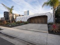 the large garage features concrete and concrete pavers, as well as two wooden panels