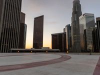 the sun sets over many skyscrapers with red stripes running from the ground to the end