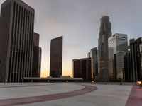 the sun sets over many skyscrapers with red stripes running from the ground to the end