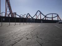 a roller coaster coaster is shown in the background and is empty parking lot at a roller coaster