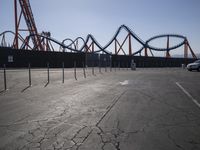 a roller coaster coaster is shown in the background and is empty parking lot at a roller coaster