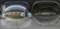 a fish eye view shows an underground station with yellow light fixtures and exposed flooring