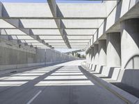 the underpass on a bridge runs along the roadway near an empty parking lot area